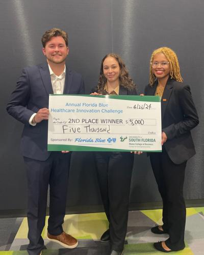photo of three biomedical engineering students holding oversized florida blue prize check