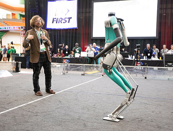 photo of robotics engineering professor christian hubicki with digit robot at first regional event in tallahassee fl