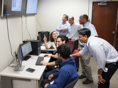 Group of researchers and students observing monitors in front of them