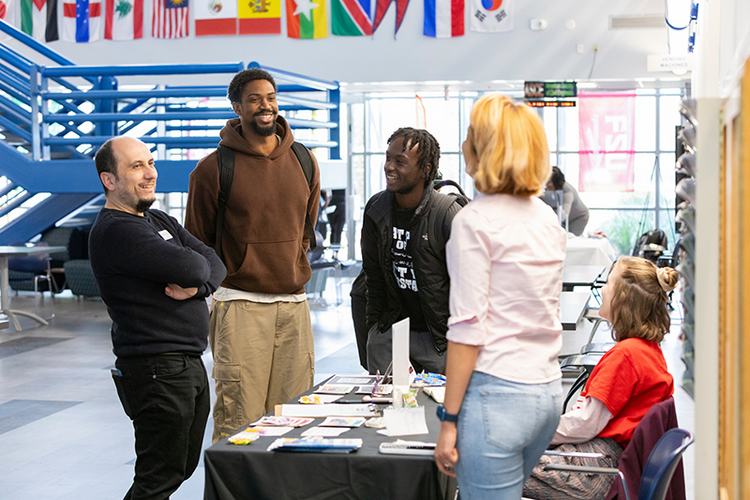 people standing around information table