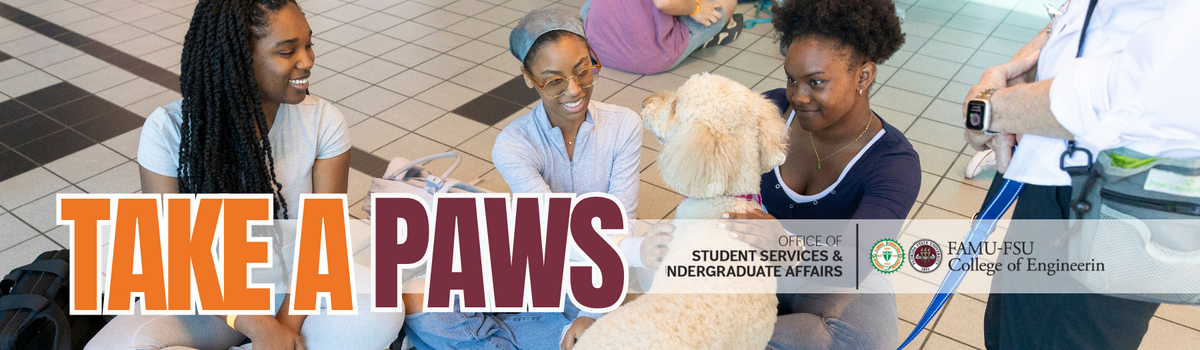 Three students pet a therpay dog at a psat Take A Paws event at the College of Engineering.