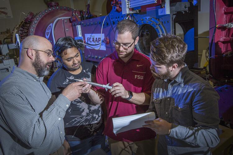 photo of group looking at model outside fcaap famu-fsu engineering wind tunnel 