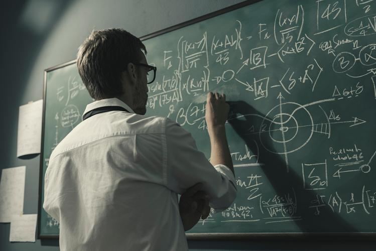 professor doing math on chalkboard
