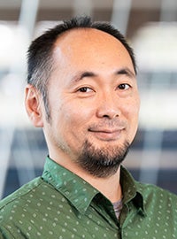photo of man with beard in green dotted shirt smiling