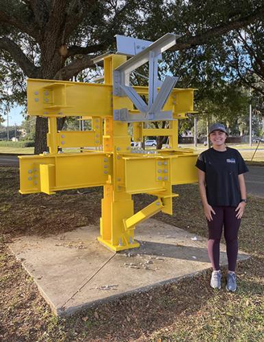 photo of lauren bishop in front of renewed engineering scuplture at famu-fsu college of engineering campus