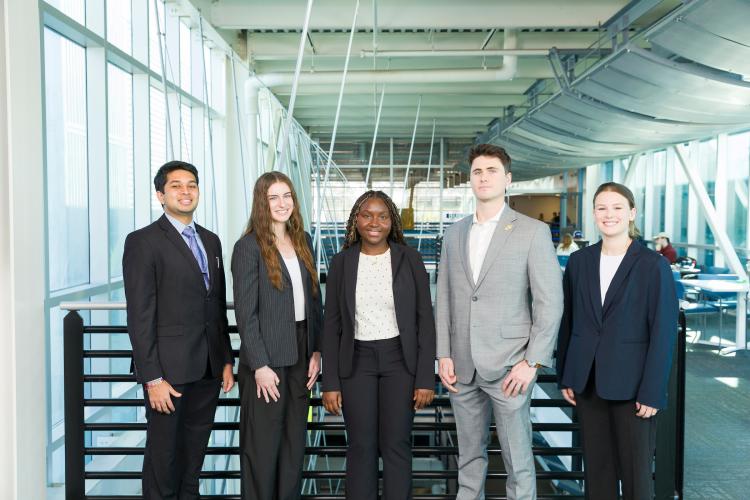 The five members of engineering senior design team 110 stand together on the third floor breezeway at the FAMU-FSU College of Engineering.