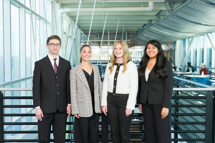 The four members of engineering senior design team 113 stand together on the third floor breezeway at the FAMU-FSU College of Engineering.