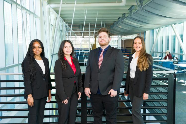 The four members of engineering senior design team 117 stand together on the third floor breezeway at the FAMU-FSU College of Engineering.