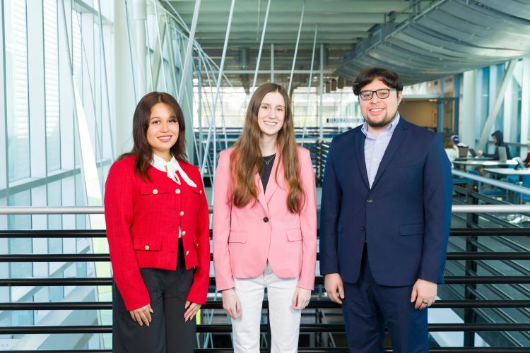 The three members of engineering senior design team 118 stand together on the third floor breezeway at the FAMU-FSU College of Engineering.