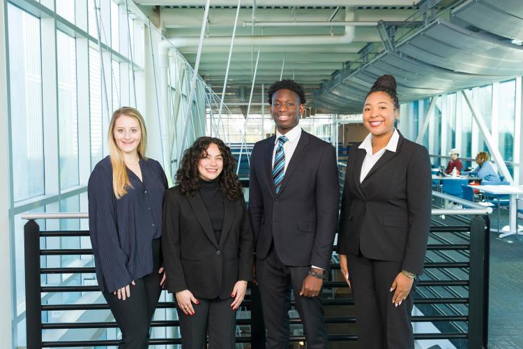 The four members of engineering senior design team 119 stand together on the third floor breezeway at the FAMU-FSU College of Engineering.