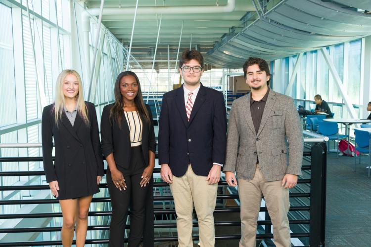 The four members of engineering senior design team 201 stand together on the third floor breezeway at the FAMU-FSU College of Engineering.