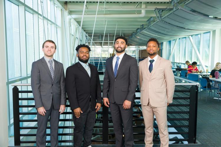 The four members of engineering senior design team 205 stand together on the third floor breezeway at the FAMU-FSU College of Engineering.