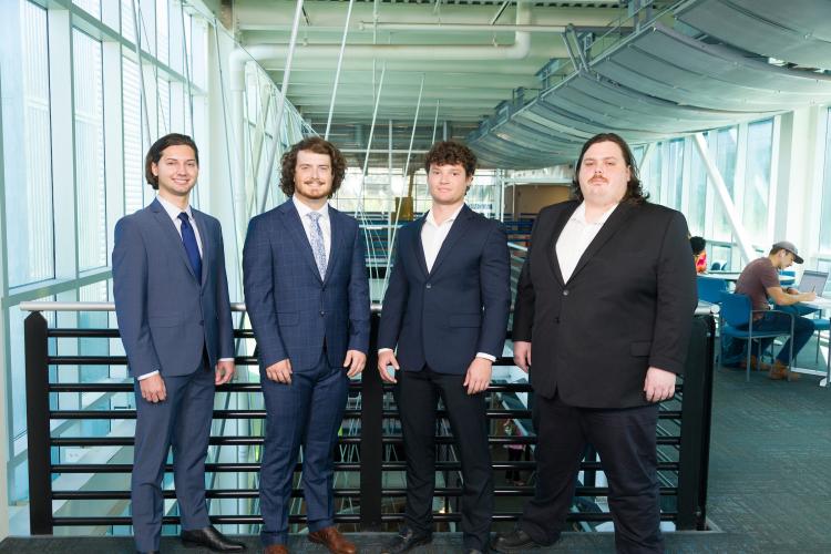 The four members of engineering senior design team 208 stand together on the third floor breezeway at the FAMU-FSU College of Engineering.