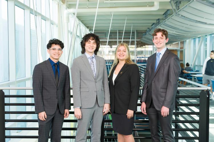 The four members of engineering senior design team 212 stand together on the third floor breezeway at the FAMU-FSU College of Engineering.