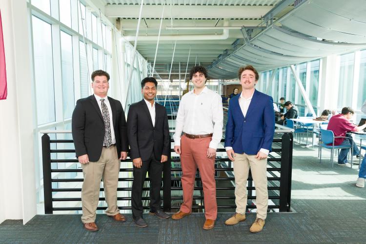 The four members of engineering senior design team 217 stand together on the third floor breezeway at the FAMU-FSU College of Engineering.