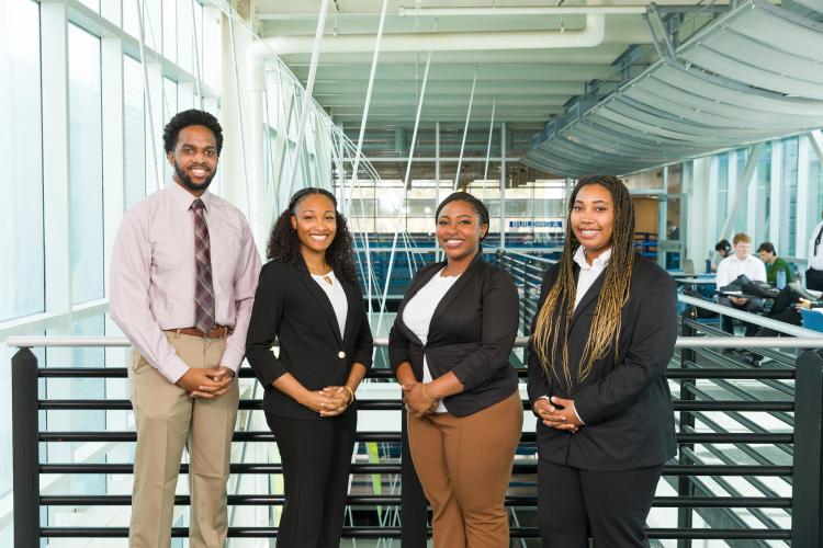 The four members of engineering senior design team 222 stand together on the third floor breezeway at the FAMU-FSU College of Engineering.