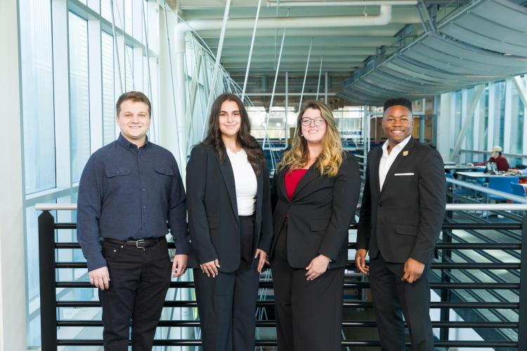The four members of engineering senior design team 104 stand together on the third floor breezeway at the FAMU-FSU College of Engineering.