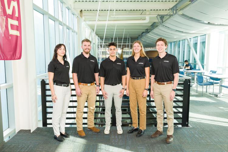 Five members of engineering senior design team 510 stand together on the third floor breezeway at the FAMU-FSU College of Engineering. The team contains six members, one of who is not pictured.