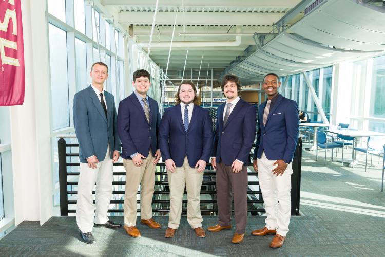 The five members of engineering senior design team 511 stand together on the third floor breezeway at the FAMU-FSU College of Engineering.