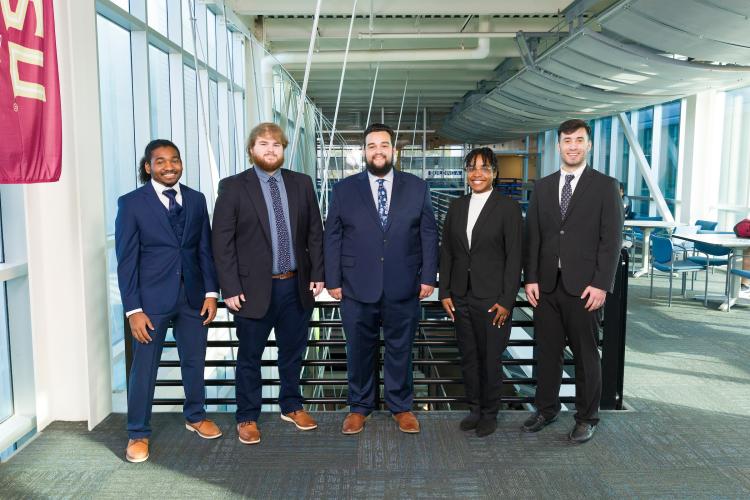 The five members of engineering senior design team 515 stand together on the third floor breezeway at the FAMU-FSU College of Engineering.