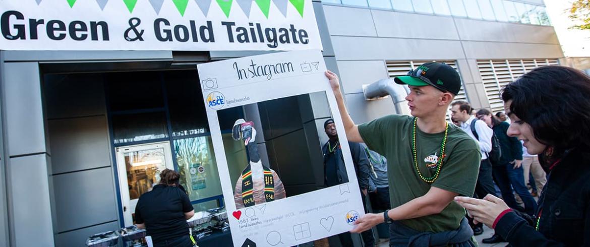 Student holding up a instagram picture frame for photo opts