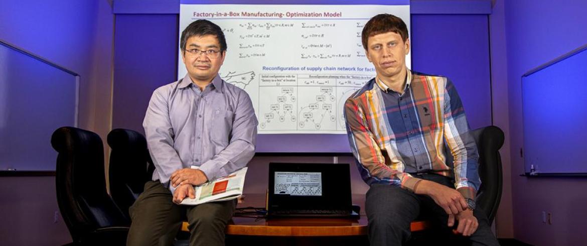 Photo of Wang and Dulebenets with laptop between them