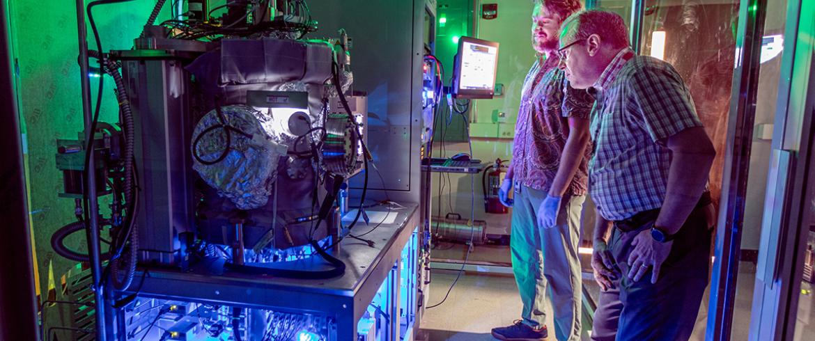 photo of lance cooley and andre juliao with the dark matter particle detector in the lab