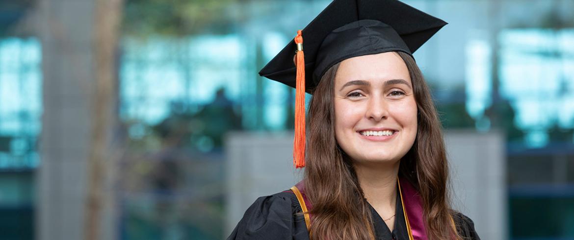 photo of lauren bishop in cap and gown in front of the famu-fsu college of engineering 