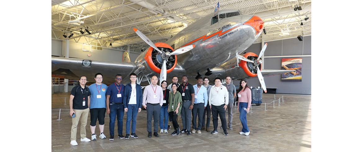 photo of engineering students and faculty in front of large antique commercial airliner