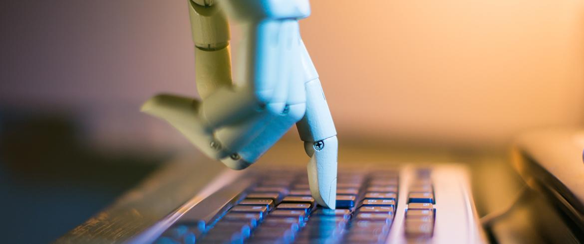 photo of robotic hand pushing a computer key