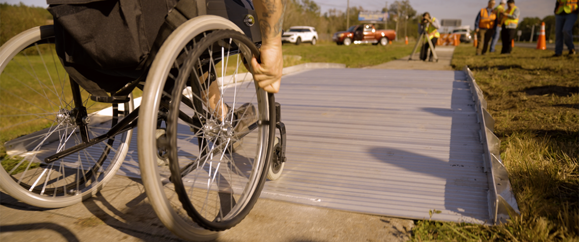closeup photo of wheelchair going across span path bridge