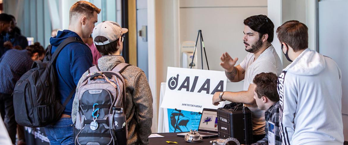 photo of male engineering students in front of info table