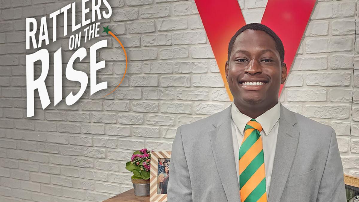 photo of black student in suit in front of verizon V