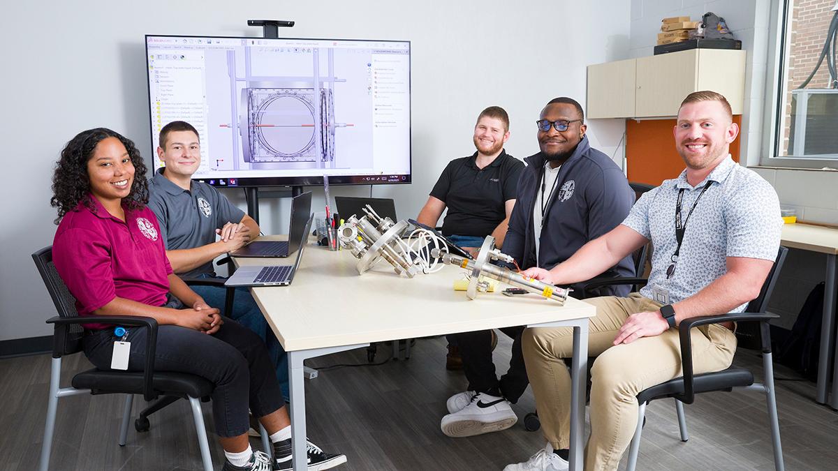 photo of CAPS IZEA team at table with computer in background