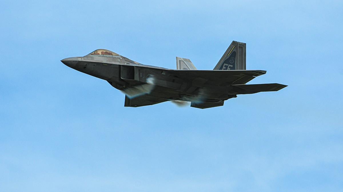 photo of modern military jet in flight against blue sky
