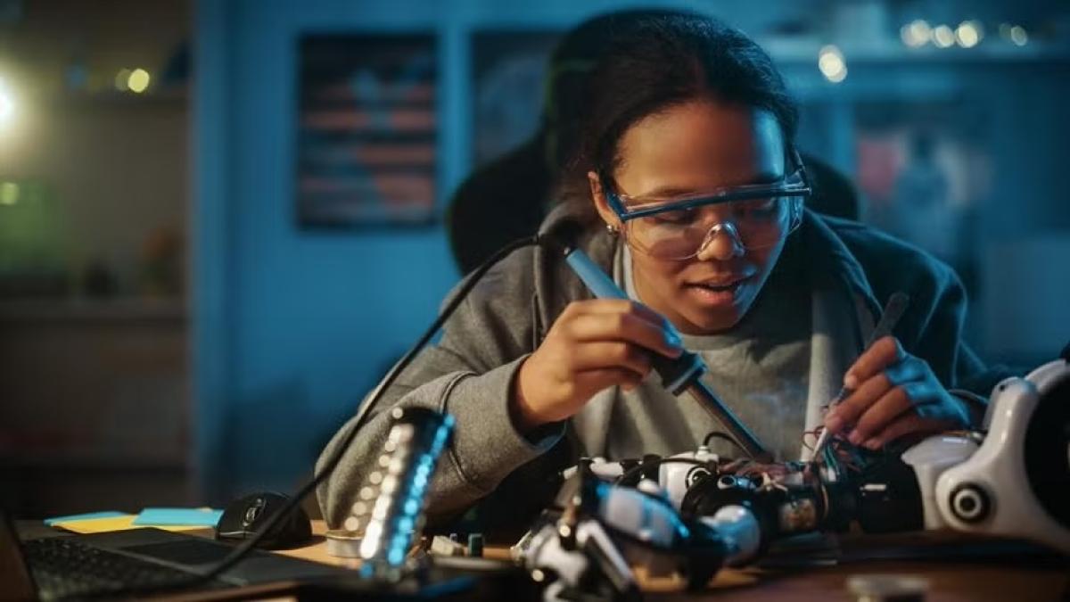 Black female engineering student soldering a unit