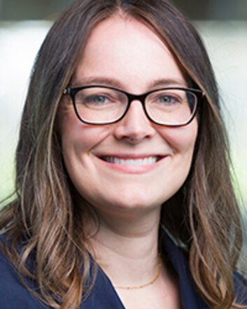 woman smiling with brown hair and glasses