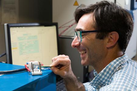 photo of famu-fsu engineering professor daniel hallinan working in lab and smiling