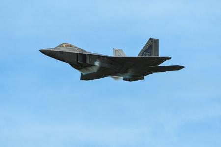 photo of modern military jet in flight against blue sky