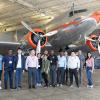 photo of engineering students and faculty in front of large antique commercial airliner