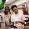 photo of professor and students with robotic arm in lab at famu-fsu engineering