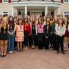 photo of students wearing neck medallions in front of fsu alumni house