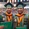 photo of twin men in famu graduation regalia holding diplomas