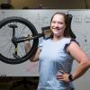 photo of taylor higgins phd with unicycle over her shoulder in front of math-filled white board at famu-fsu engineering