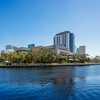 downtown buildings photo with river in front and blue sky